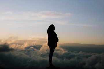 Silhouette of a woman in the cloud covered mountains
