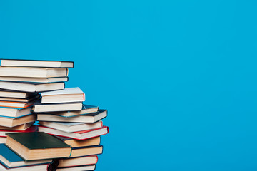 lots of stacks of educational books to teach in the school library on a blue background