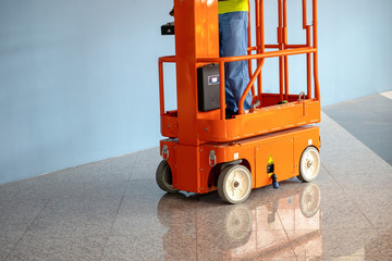 DUBAI, UAE - MARCH 24: Orange hydraulic scissor platform stand by for service and maintenance in...