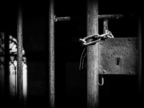 Cerradura y cadena en la reja de una tumba en el cementerio