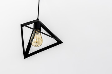 triangle black chandelier hanging on ceiling and retro antique bulb on white blank background