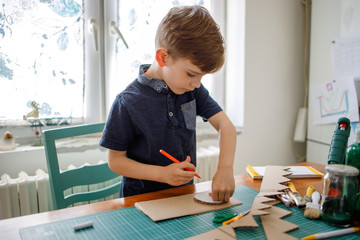  Smiling boy making a cardboard dinosaur costume