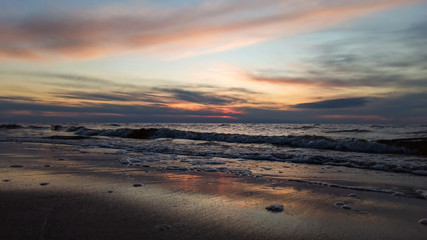 Obraz premium Beautiful Sunrise Over Batlic Sea With Majestic Sky Light Being Reflected. Waves Slowly Rolling in on the Beach. Vecaki beach Riga, Latvia.