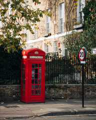 Iconic Red phone booth in residential street in London, United Kingdom