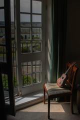 Obraz na płótnie Canvas Shiny ukelele in front of a balcony in a dark room