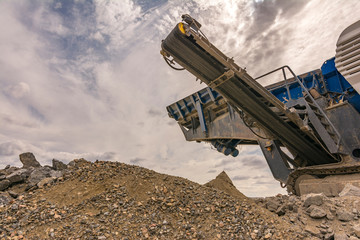 Heavy and mobile machinery in a quarry to transform stone into construction material