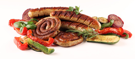 Assorted delicious grilled meat with vegetable on a barbecue with grilled sausages and vegetables on table