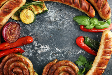 Assorted delicious grilled meat with vegetable on a barbecue with grilled sausages and vegetables on table