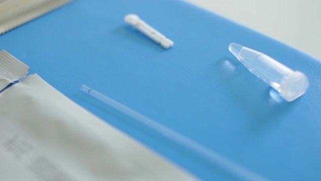 Work of the laboratory during the coronavirus pandemic. Commercial and state laboratories. Close up of a doctors hand lays on the table a used test cassette express test covid-19