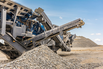 Heavy and mobile machinery in a quarry to transform stone into construction material