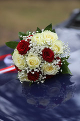 wedding bouquet of roses on the bonnet of a wedding car