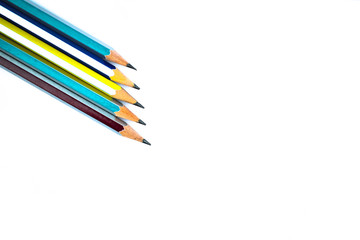 Five different colored wood pencil crayons arranged on a white background