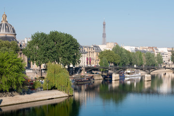 Obraz premium reflection in the Seine river view of the city of Paris France with morning light from a bridge 