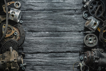 Old car spare parts on a black wooden workbench flat lay background with copy space.