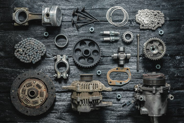 Old car spare parts on a black wooden workbench flat lay background.