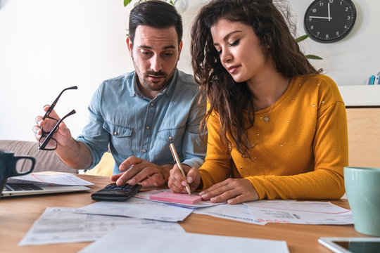 Stressed man and woman talking about family budget,  calculating household bills and expenses at desk stock photo