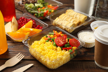 Food delivery. Food in takeaway boxes on wooden table