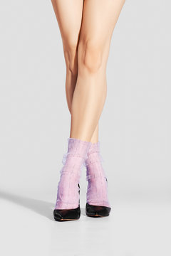 Cropped image of slim female legs in tulle socks and black stilettos