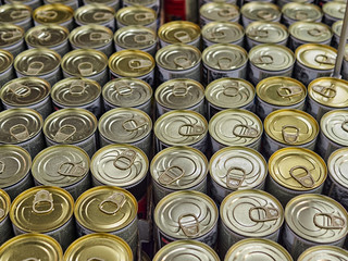 Iron cans with canned goods in a store on the counter. A lot of goods in the supermarket