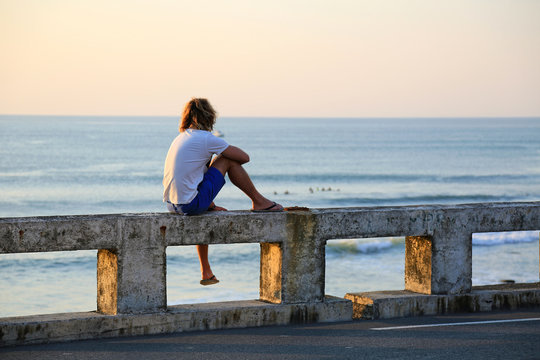hombre joven rubio sentado mirando al mar atardecer U84A4564-as20