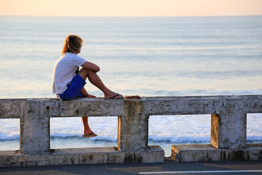 hombre joven rubio sentado mirando al mar atardecer U84A4566-as20