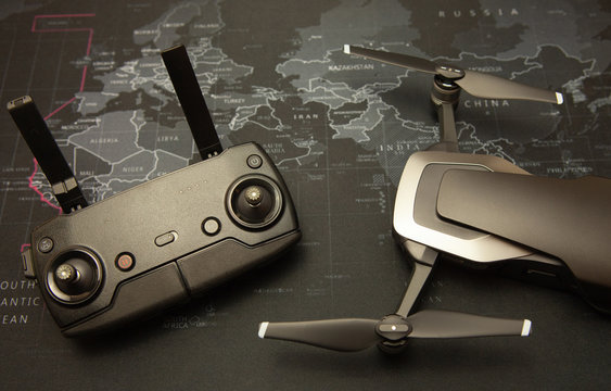 Modern flying device - a drone with a remote control on a map background