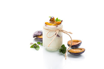 Homemade sweet yogurt with slices of ripe plums in a glass