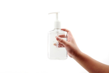 Fighting Coronavirus concept. Prevent COVID-19 virus infection and spread. Child hand holding hand sanitizer isolated on a white background. Selective focus, copy space and close up.