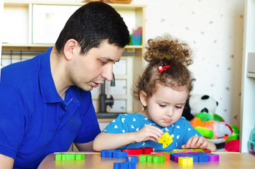 Obraz premium Dad and daughter draw, play, make applications, spend time together. kids leisure, quarantined classes, in self-isolation. father's day. Children Protection Day.