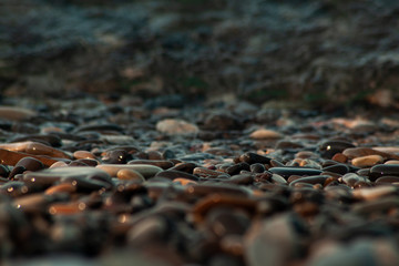 Obraz premium pebble stones by the sea. Silky waves of blue sea from long exposure. background
