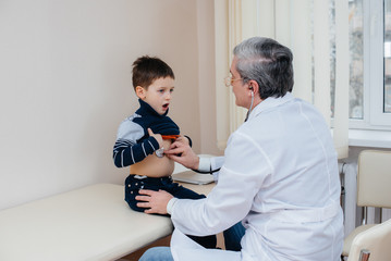 A young boy is listened to and treated by an experienced doctor in a modern clinic. A virus, and an epidemic