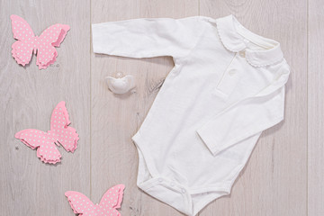 baby clothes concept. white outfit for girl on wooden background
