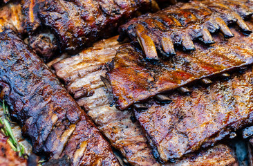 Close-up view on a group of grilled ribs. Juicy tasty BBQ meat