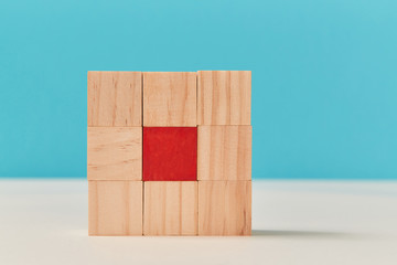 Square of wooden cubes with one red in centre. Mockup style for creative design, copy space. Personal identity concept