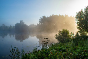 
fog over the lake in the rays of the rising sun