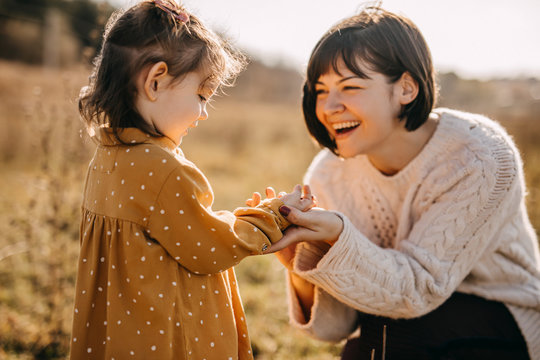 Mother and daughter playing outside on a sunny day.