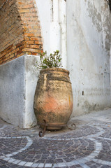 Fototapeta premium Decorative ceramic vase and paving stones on a street of an old town in Amalfi, Italy
