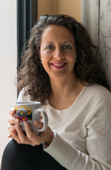 A woman with a cup in her hands.