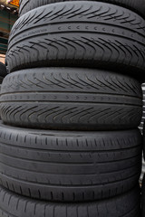 stack of used tires, the bottom has a directional asymmetrical tread pattern for all weather use, and the top two have directional, also called unidirectional, treads best for wet conditions