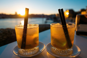 Two beverages cocktails at sunset with straws