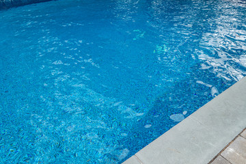 blue gound pool with wavy highlights and cement and brick circumference masonry