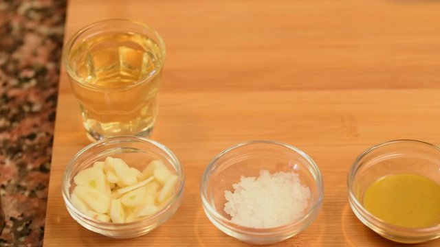 ingredients in a line, orange, peppers paste, mostard,salt, garlic, wine and peeper.