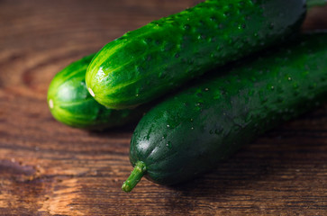 Fresh green organic cucumbers on wooden background