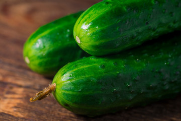 Fresh green organic cucumbers on wooden background