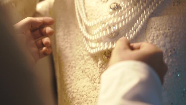 Frontview of chest of man in traditional indian white clothes, groom dressing up for the wedding ceremony, pearls, necklace, wedding accessory for groom