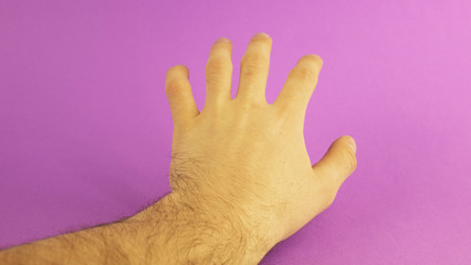 left male hand in the center on a purple background