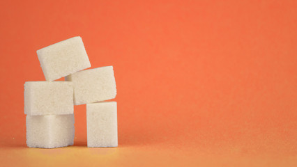 white sugar cubes lie on a red background