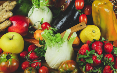 full frame of a rustic composition of fruit and vegetables arranged on a table