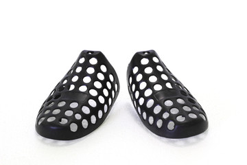 Black plastic shoe tree shaper. Form handler for new products. Modern design. White background.