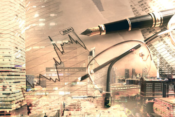 Banking and finance background.Finance and business concept.Pen,calculator over graphs and charts.Double exposure with city lights